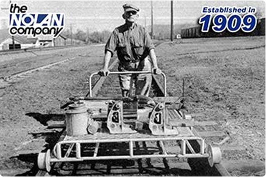 nolan-history An employee of The Nolan Company pushes a cart along a train track.
