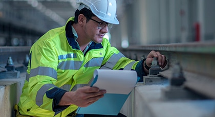 A technician examines a portion of railroad track